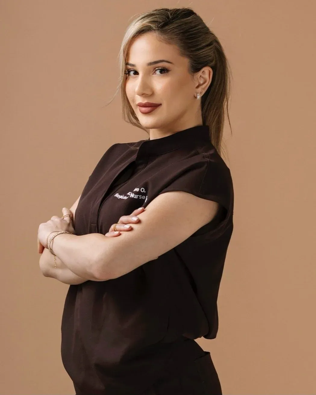 Katherine Oganesyan, RN, arms crossed in embroidered scrubs
